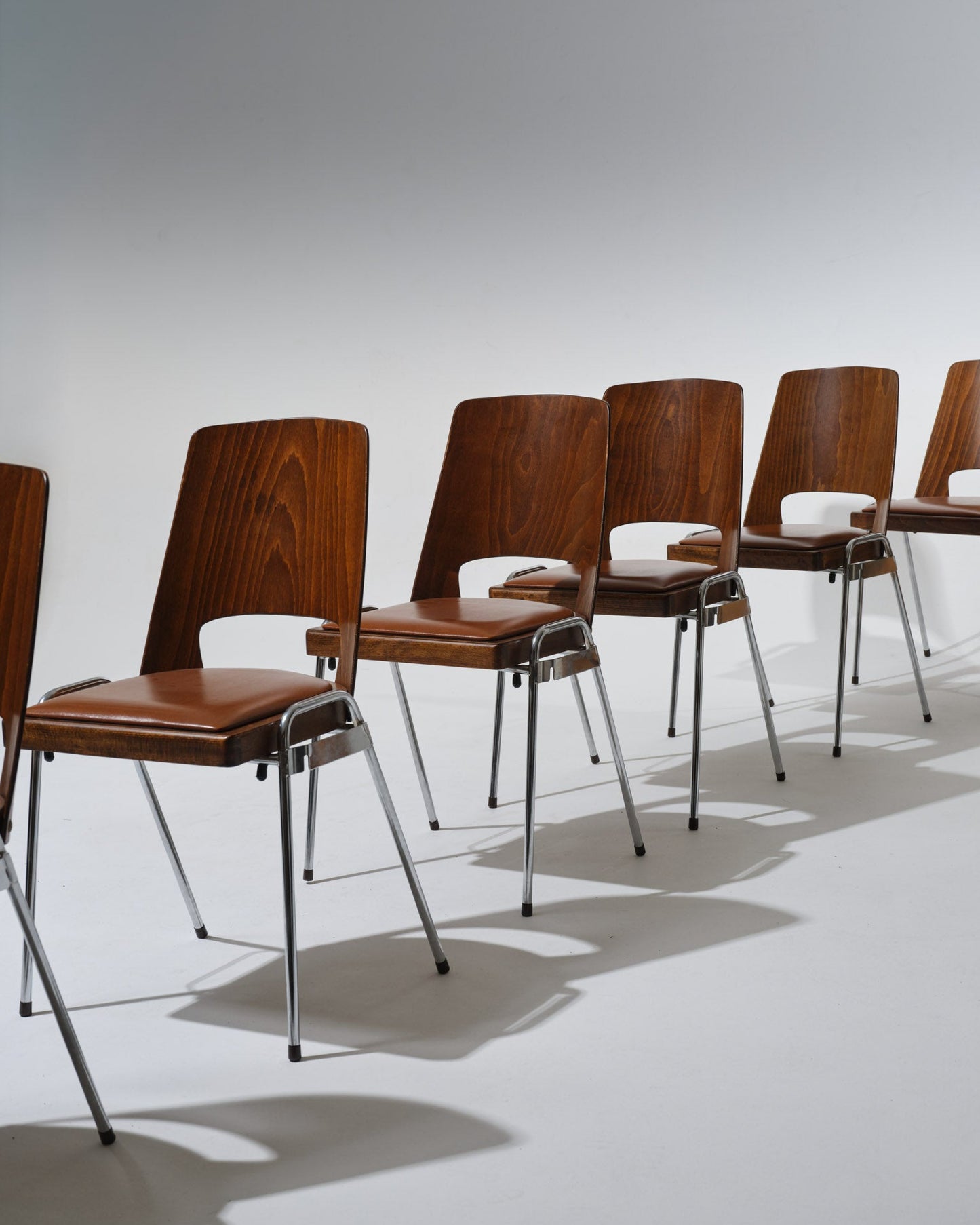 Set de 6 chaises éditée par Baumann dans les années 1970. Structure en hêtre cintré, assise et dossier en skaï cognac, piètement en acier chromé. Un modèle fonctionnel et confortable, typique des créations Baumann destinées aux espaces collectifs.
Parfait état.