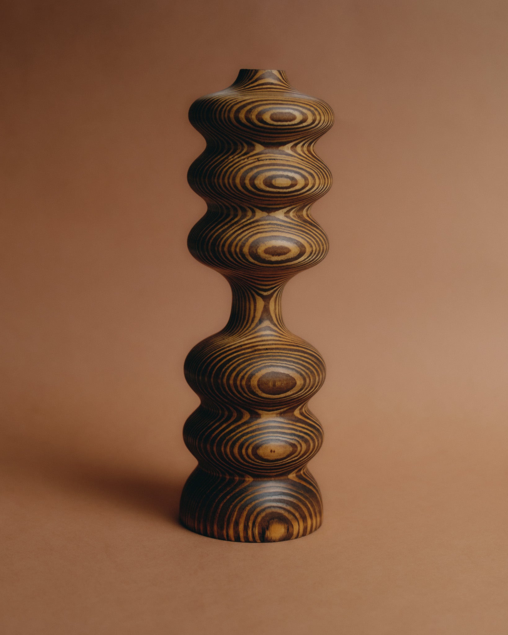 Bougeoir en bois tourné, modèle Marcel par Hugo Periesse. Pièce contemporaine à la silhouette sculpturale et organique, travaillée dans une essence veinée révélant des jeux de cercles concentriques. Pièce signée sous la base.