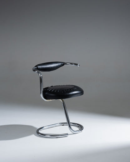 Chaise modèle "Cobra" du designer italien Giotto Stoppino (1926–2011). Structure en acier tubulaire chromé, réalisée d’une seule pièce intégrant la base, l’assise et le dossier. Revêtement en simili cuir noir déhoussable, avec étiquette d’origine sous l’assise.&nbsp;
Bel état général, à noter de légères traces d'usage : craquelures visibles sur le dossier (voir photos).&nbsp;