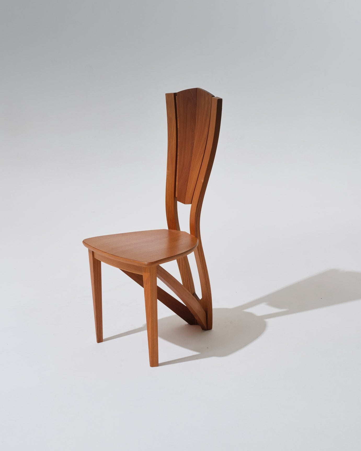 Chaise sculpturale réalisé en orme massif, signature du savoir-faire de la maison Seltz. Le dossier en éventail et les lignes galbées confèrent une allure équilibrée. La teinte miel doré du bois met en valeur le veinage naturel et la chaleur du matériau.
Très bon état général, belle patine du bois.
