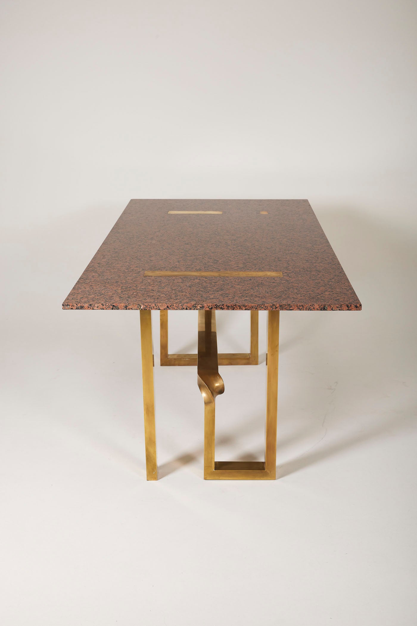 Table à manger en granit rose et laiton du designer Alfrefo Freda pour Cittone Oggi, années 1960. Le plateau est en granit rose. Le piètement est en laiton. Cette table est signée sur le piètement. Très bon état.