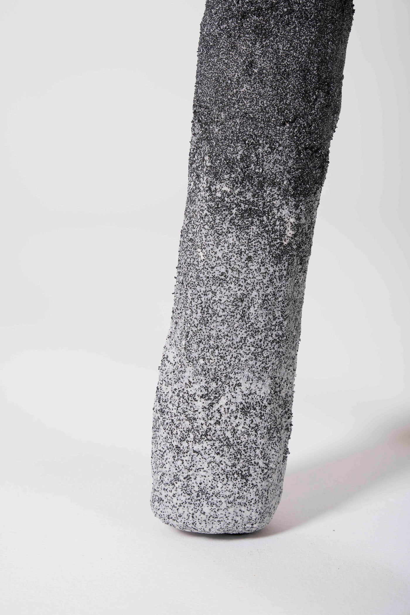 Un tabouret en plâtre et sable gris clair et noir du designer Paul Hardy. En parfait état.