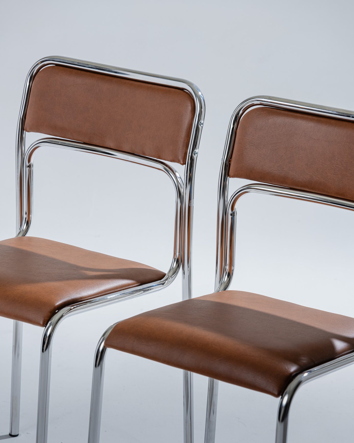 PAIR OF TUBULAR STEEL AND COGNAC LEATHERETTE CHAIRS, 1980s