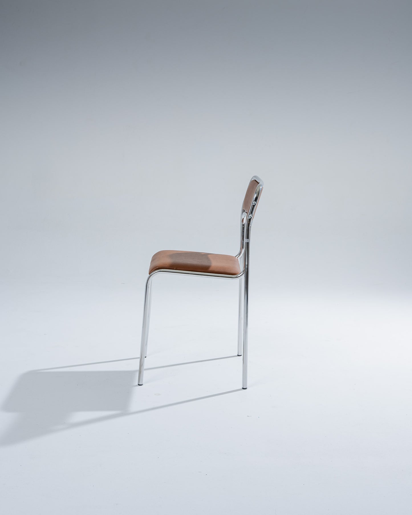 SET OF 4 CHAIRS IN TUBULAR STEEL AND COGNAC LEATHERETTE, 1980s