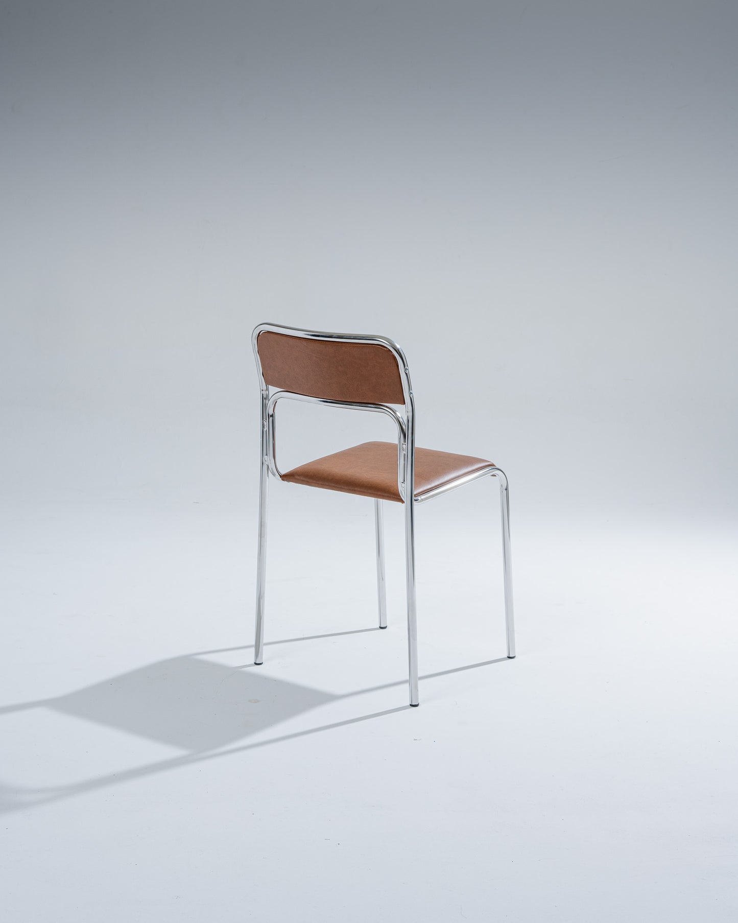 PAIR OF TUBULAR STEEL AND COGNAC LEATHERETTE CHAIRS, 1980s