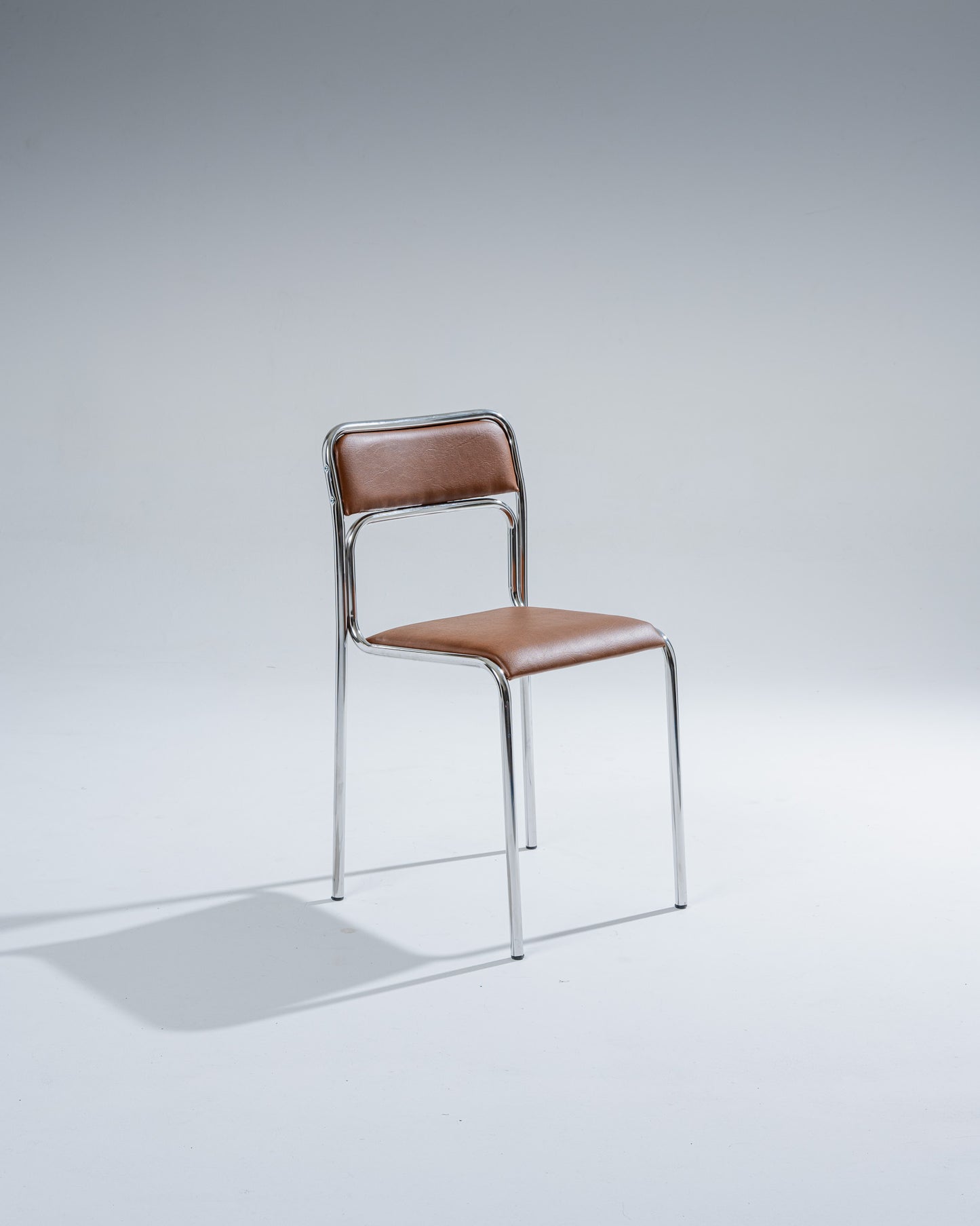 PAIR OF TUBULAR STEEL AND COGNAC LEATHERETTE CHAIRS, 1980s