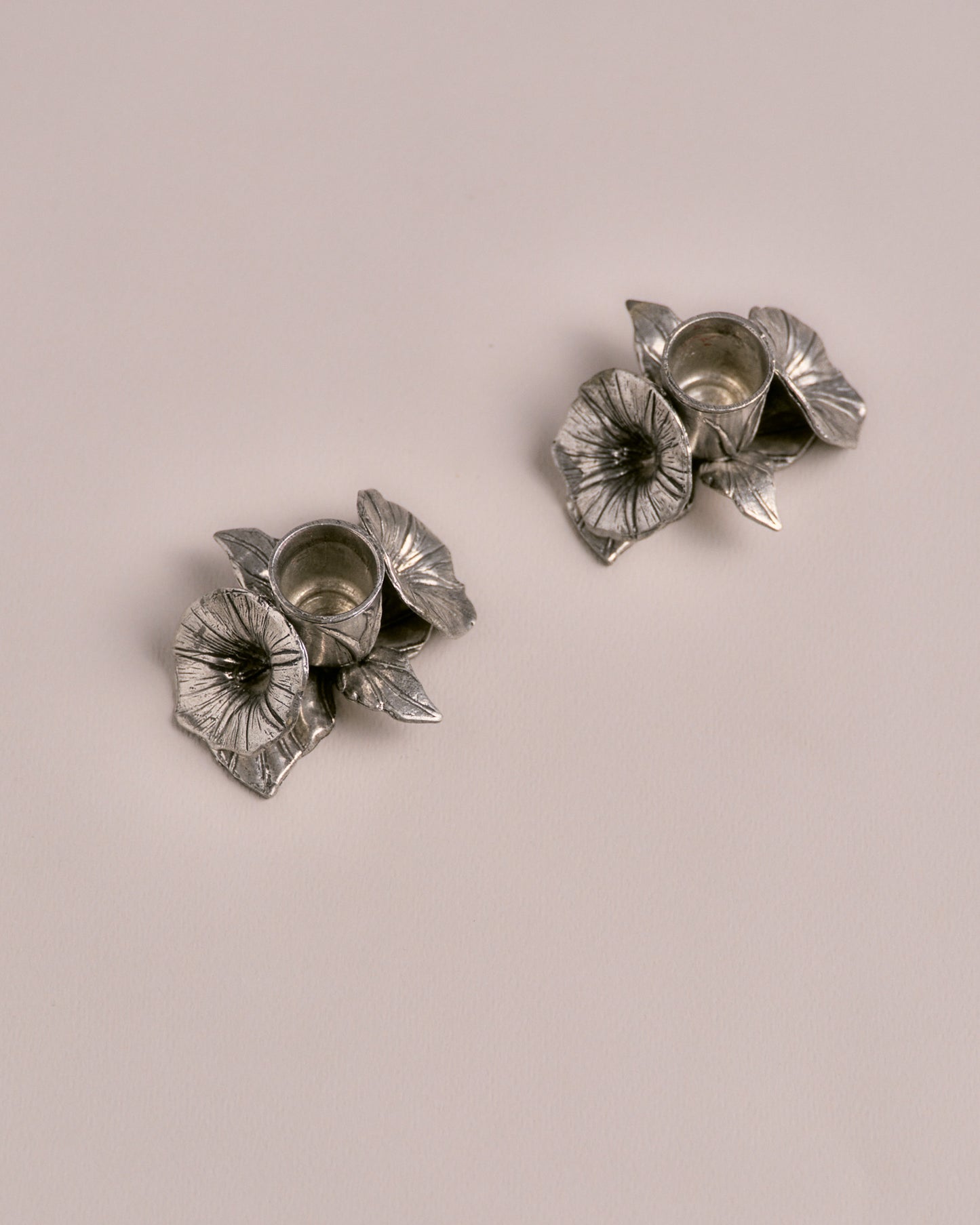 PAIRE DE BOUGEOIRS FLEURIS UN FEU EN ÉTAIN