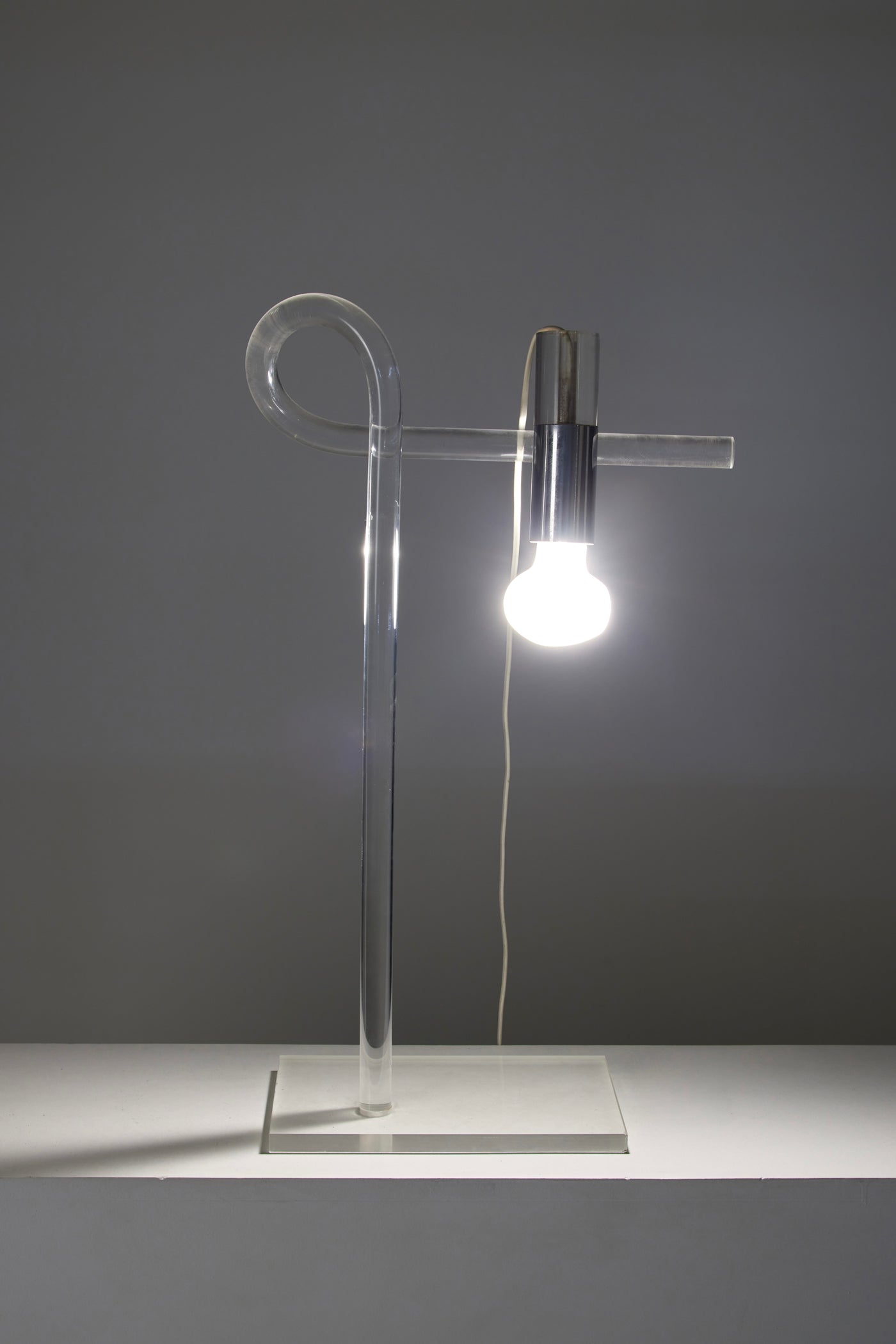 Lampe de table Crylicord du designer Peter Hamburger édition Knoll, années 1970. Structure en altuglas coudée à base rectangulaire et métal chromé. Très bel état avec quelques traces d'usage.