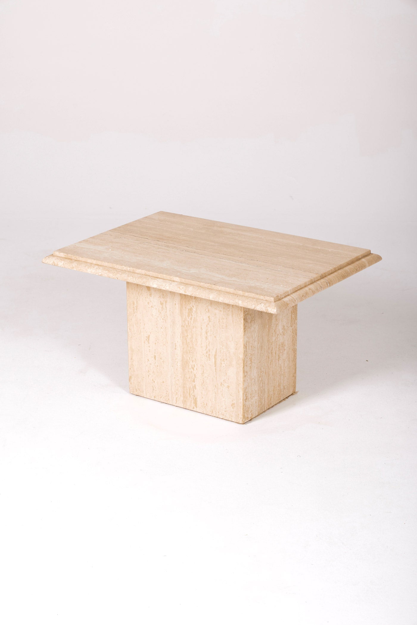 Table d'appoint ou table basse rectangulaire en travertin des années 1970. Le plateau et le pied se désolidarisent. Intemporel, le travertin est une matière qui se mélange aux pièces des années 1950 aux années 1980. Deux tables disponibles. 
