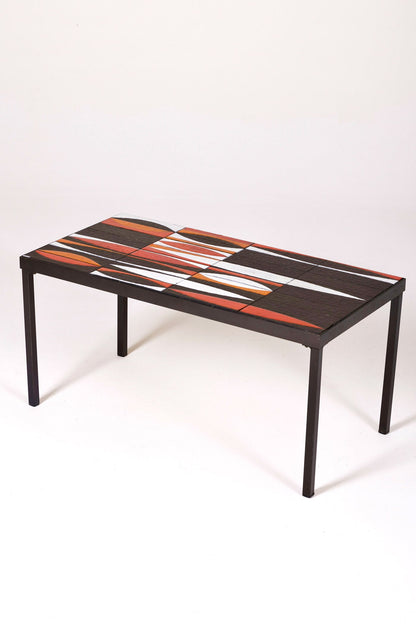 Table basse en céramique modèle Navette du céramiste Roger Capron, années 1960. La structure est en métal laqué noir et le plateau en céramique émaillée rouge, noir et blanc. Table signée R. Capron sur le coin. En parfait état. 