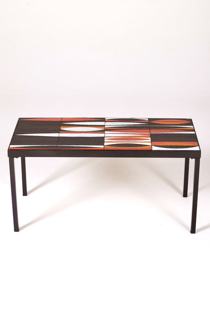 Table basse en céramique modèle Navette du céramiste Roger Capron, années 1960. La structure est en métal laqué noir et le plateau en céramique émaillée rouge, noir et blanc. Table signée R. Capron sur le coin. En parfait état. 