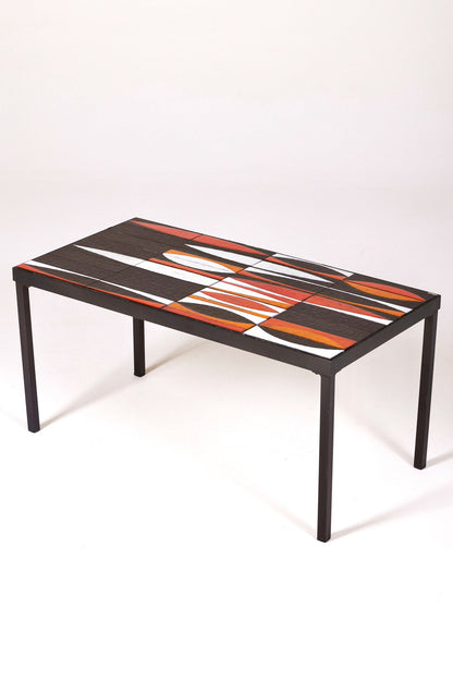 Table basse en céramique modèle Navette du céramiste Roger Capron, années 1960. La structure est en métal laqué noir et le plateau en céramique émaillée rouge, noir et blanc. Table signée R. Capron sur le coin. En parfait état. 