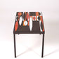 Table basse en céramique modèle Navette du céramiste Roger Capron, années 1960. La structure est en métal laqué noir et le plateau en céramique émaillée rouge, noir et blanc. Table signée R. Capron sur le coin. En parfait état. 