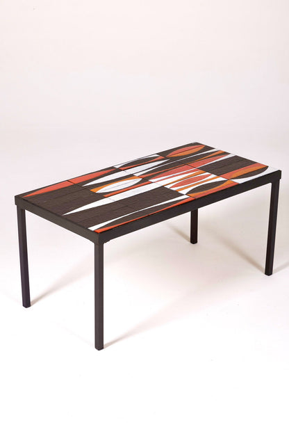 Table basse en céramique modèle Navette du céramiste Roger Capron, années 1960. La structure est en métal laqué noir et le plateau en céramique émaillée rouge, noir et blanc. Table signée R. Capron sur le coin. En parfait état. 