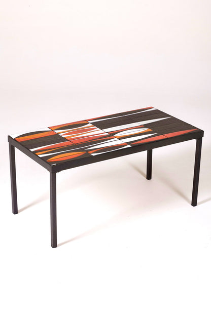 Table basse en céramique modèle Navette du céramiste Roger Capron, années 1960. La structure est en métal laqué noir et le plateau en céramique émaillée rouge, noir et blanc. Table signée R. Capron sur le coin. En parfait état. 