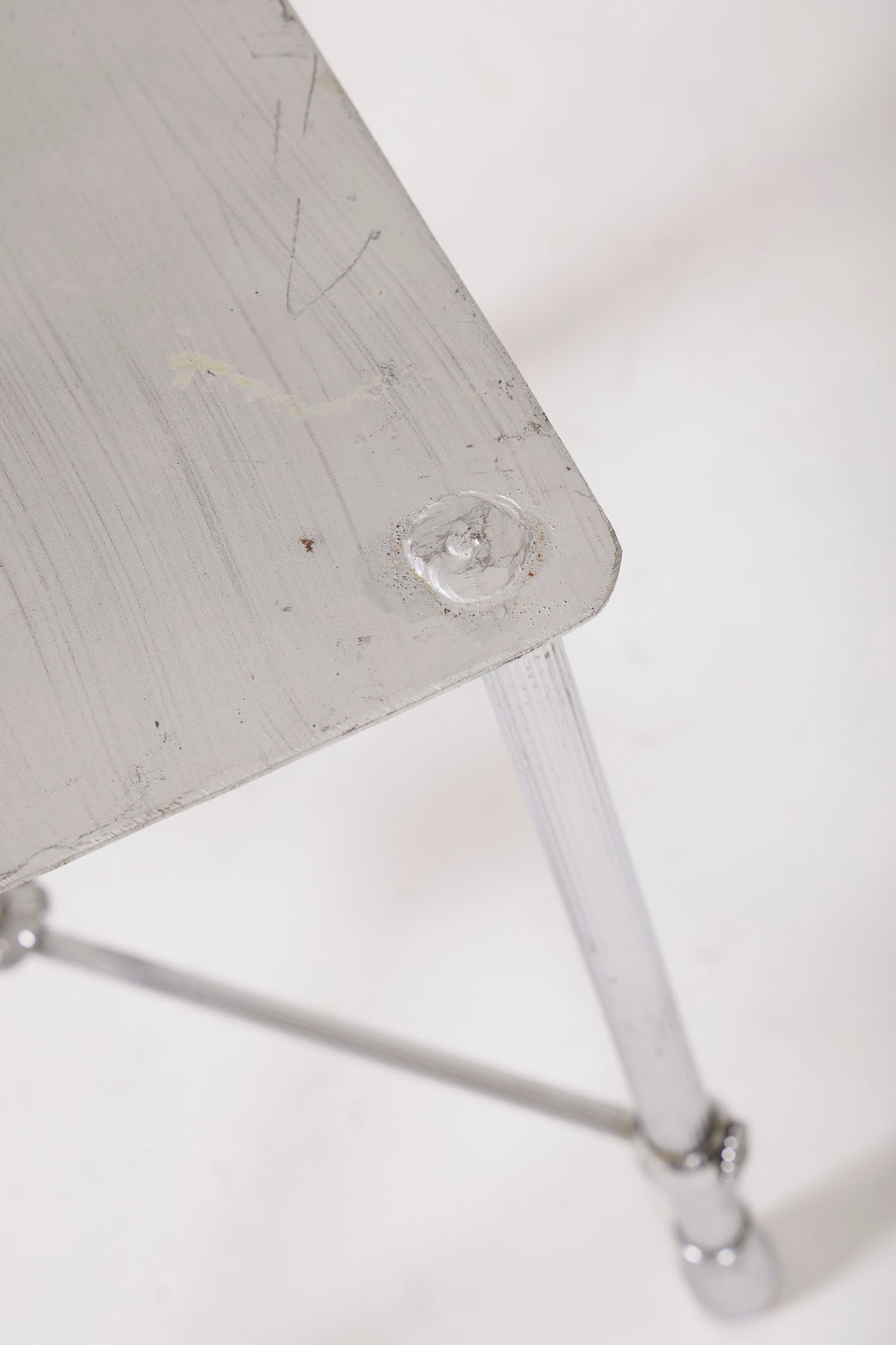 Tabouret carré en métal de couleur argenté, en bon état général. Quelques traces d'usure mineures sont à noter, ce qui ajoute un caractère authentique à ce meuble.