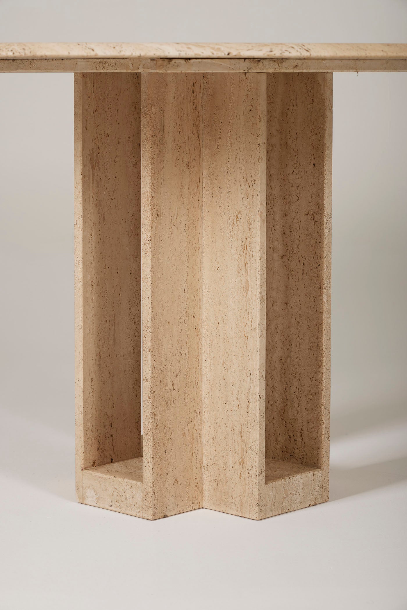 Table à manger en travertin des années 1970. Le plateau octogonale repose sur son piedestal en forme de croix. Le travertin est une roche naturelle calcaire sédimentaire qui se marie aussi bien avec du bois, du marbre ou du métal. Bon état général.