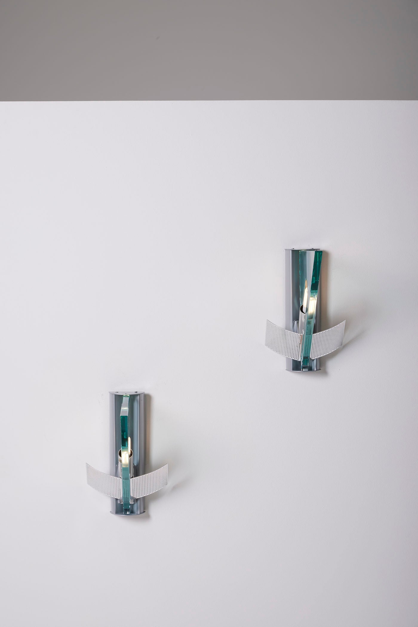 Paire d'appliques modèle Icaro du designer Carlo Forcolini pour Artemide, années 1980. Ces appliques sont en métal et verre, le reflecteur est en métal ajouré. Très bon état.