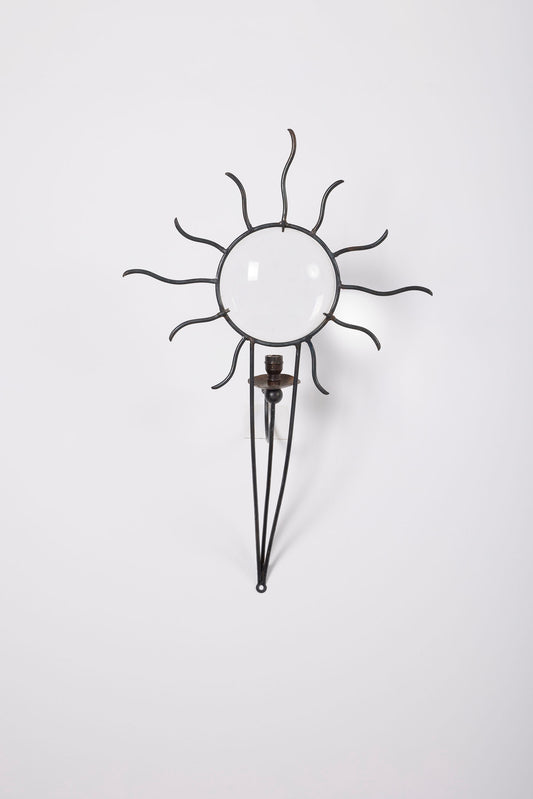 Grande applique modèle Soleil en fer forgé du designer André Dubreuil (né en 1951), années 1980. Elle est constituée d'une lentille en verre et d'une stucture en fer forgé. Très bel état.