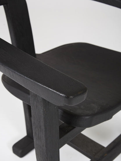 Chaise trône en bois massif teinté noir du designer Rudi Muth, 1987. Elle est signée et datée à la main sous l’assise. Bon état, légères traces d’usure.