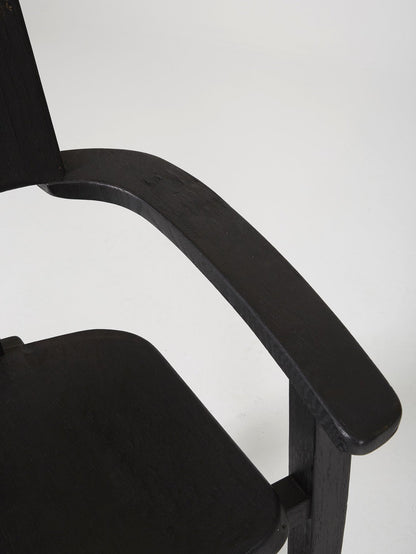 Chaise trône en bois massif teinté noir du designer Rudi Muth, 1987. Elle est signée et datée à la main sous l’assise. Bon état, légères traces d’usure.