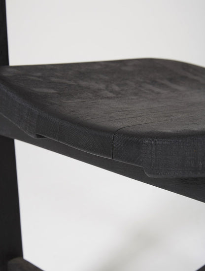 Chaise trône en bois massif teinté noir du designer Rudi Muth, 1987. Elle est signée et datée à la main sous l’assise. Bon état, légères traces d’usure.