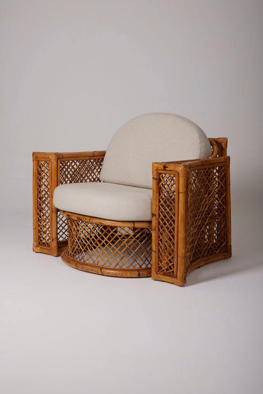Un salon en rotin tressé composé d'une paire de fauteuils et d'un repose pied, années 1940. Assise et dossier en tissu beige. En parfait état.