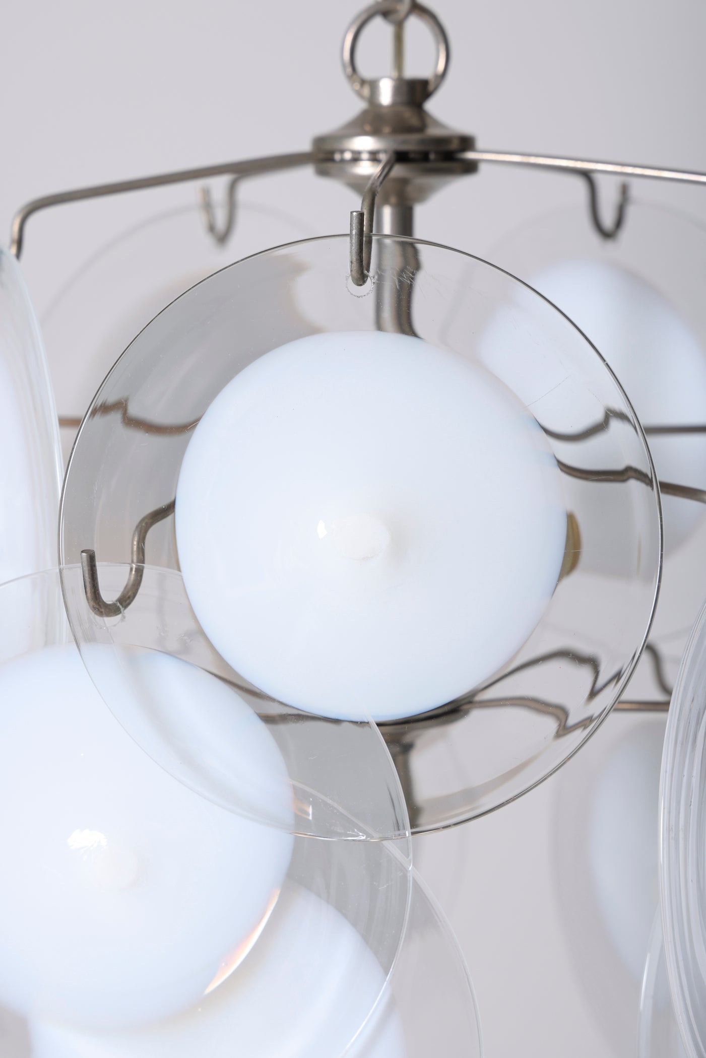 Lustre en verre vénitien de Murano du designer italien Gino Vistosi pour Venini. Ce lustre est composé de 16 disques de verre soufflé de Murano transparent avec une inclusion de verre blanc et structure en métal chromé. Bon état malgré de légères marques du temps. 
