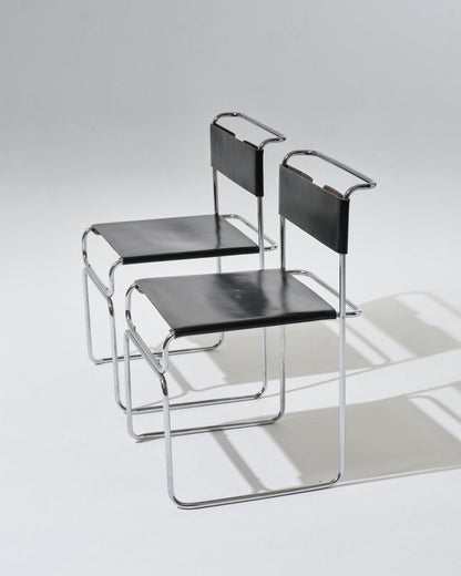 Paire de chaises Libellula dessinées par Giovanni Carini pour Tisettanta. Structure en acier tubulaire chromé, assise et dossier en cuir noir tendu, maintenus par un système de ressorts métalliques apparent à l'arrière.
Bon état général, à noter de légères marques visibles (voir photos).