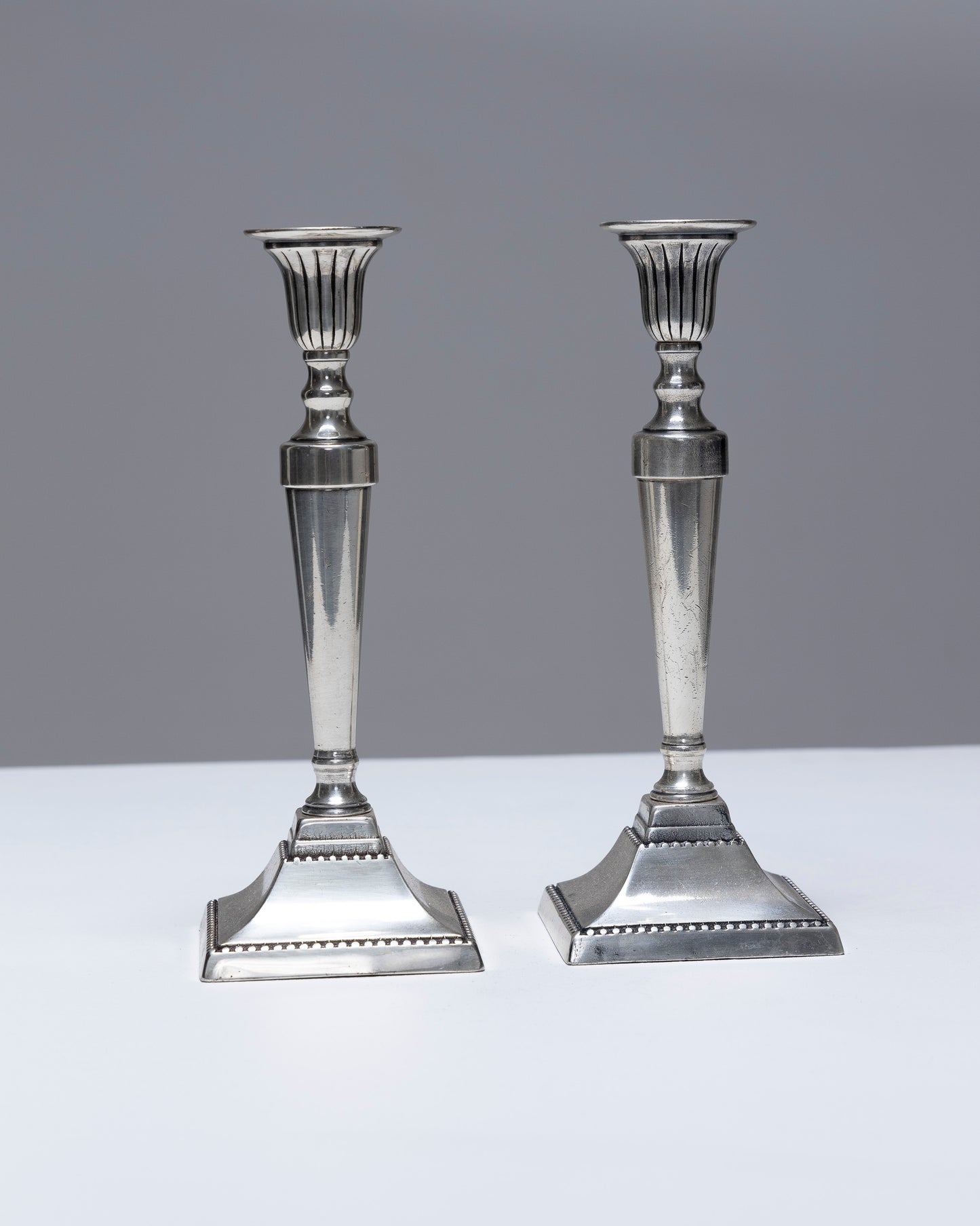 PAIR OF METAL FLAMBEAU CANDLESTICKS