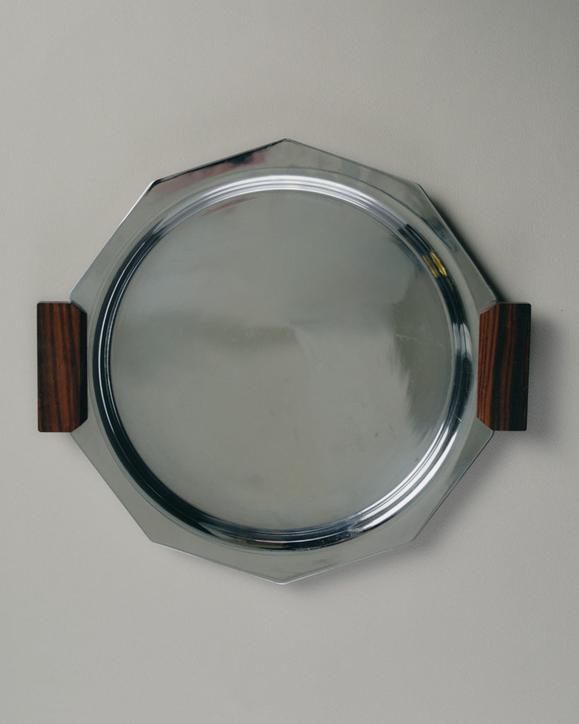 Plateau de service octogonal en métal argenté, orné de poignées latérales en palissandre. Travail français des années 1930, typique du style Art Déco par l'équilibre géométrique et l'association de matériaux contrastés.

Bon état général, présentant quelques traces d'usage conformes à l'âge.