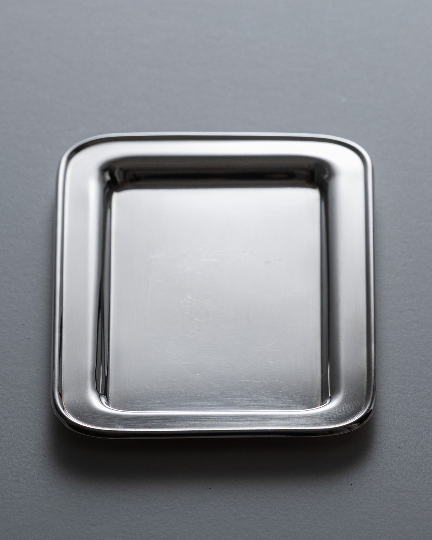 Plateau de service rectangulaire en métal argenté par l’orfèvre français Ercuis. Contour perlé et poignées ajourées à volutes, caractéristiques des productions de la maison.&nbsp;

Bel état général, légère patine conforme à l'âge.