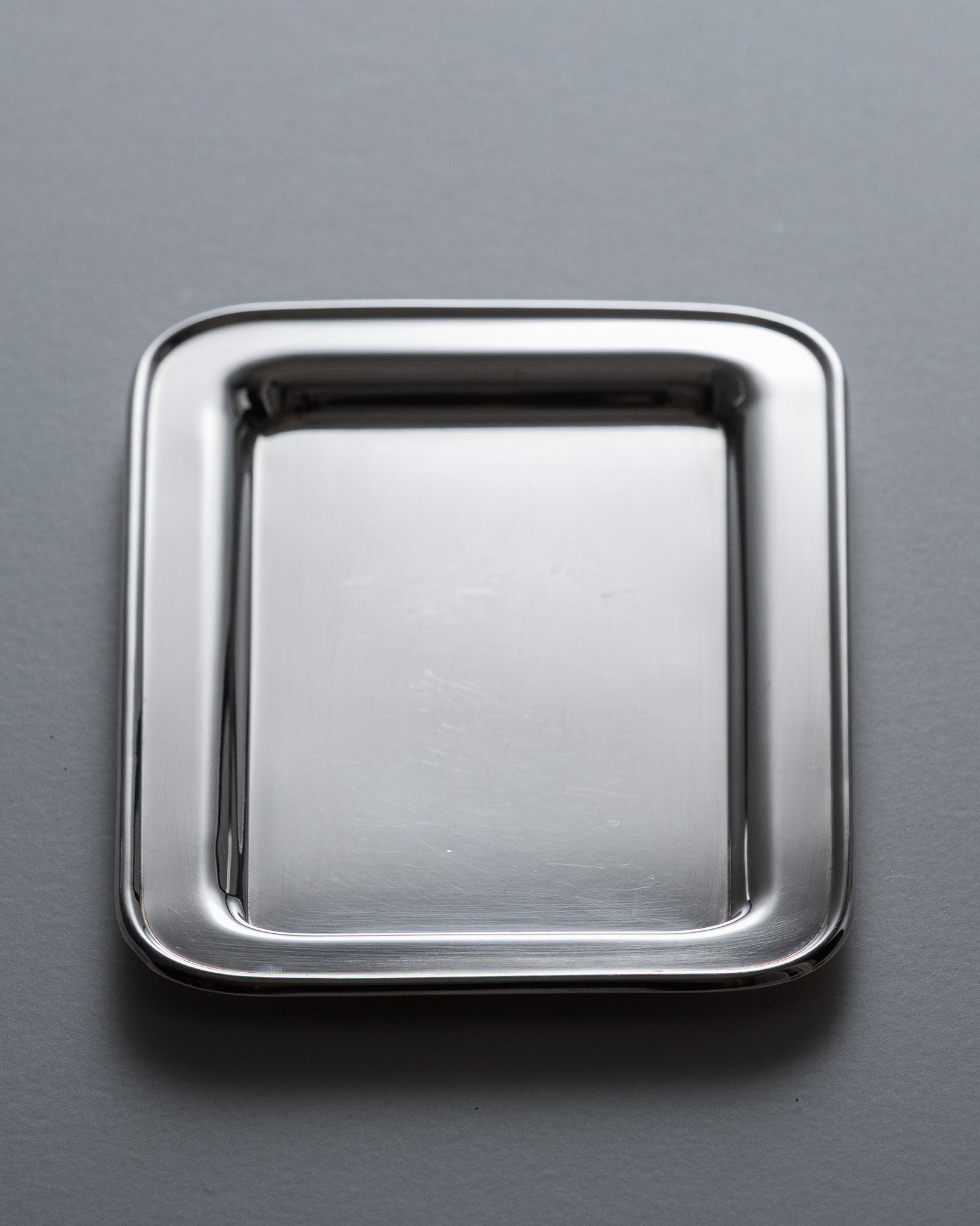 Plateau de service rectangulaire en métal argenté par l’orfèvre français Ercuis. Contour perlé et poignées ajourées à volutes, caractéristiques des productions de la maison.&nbsp;

Bel état général, légère patine conforme à l'âge.