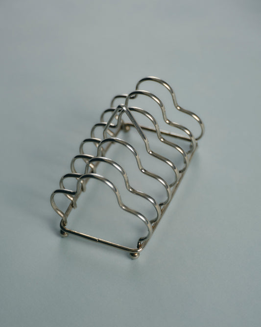 Porte-toasts en métal argenté, à structure filaire ondulée formant cinq compartiments. Bel état général, patine légère conforme à l'usage.