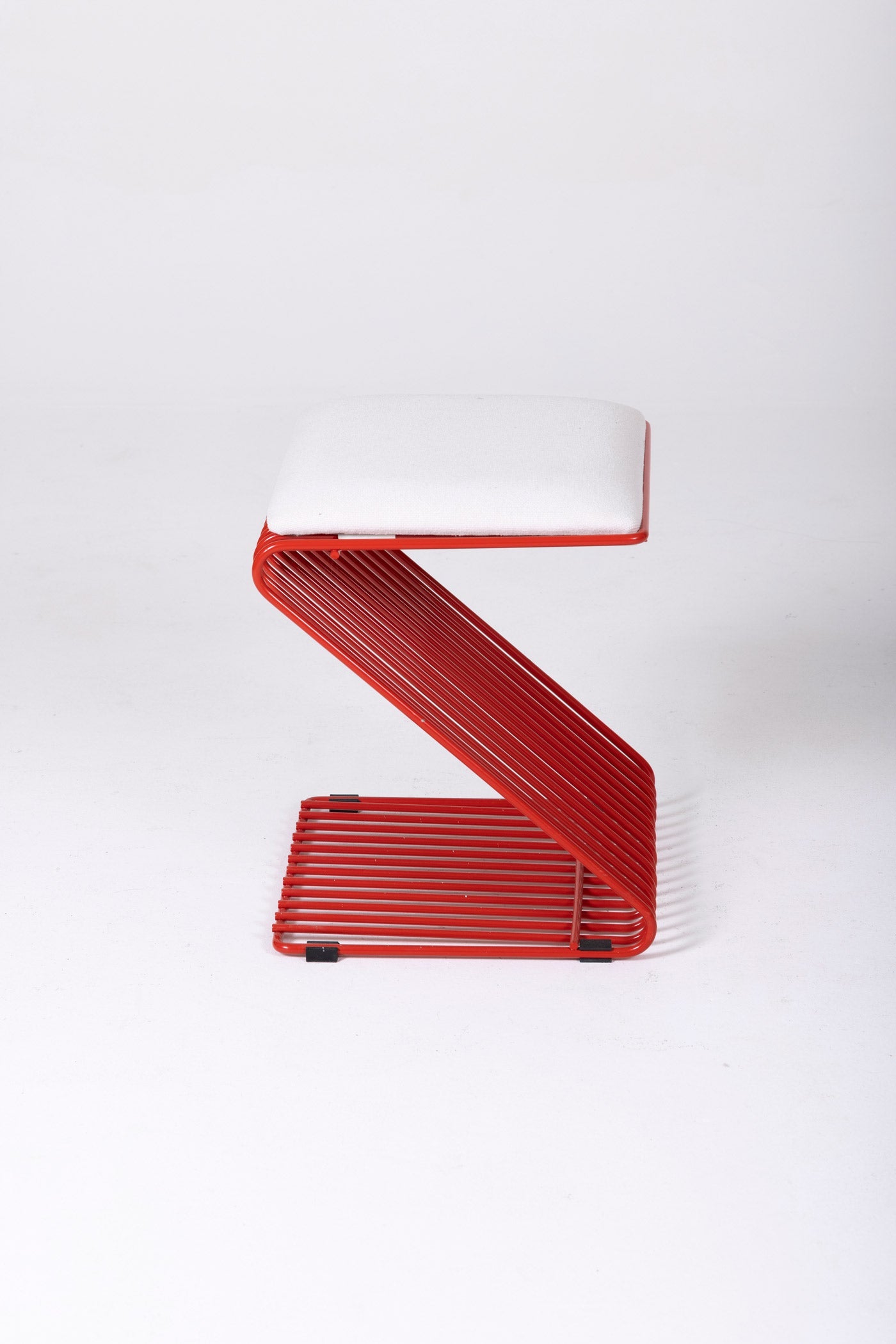 Tabouret Z du designer François Arnal pour l'Atelier A. Le coussin est en textile blanc et la structure tubulaire en métal laqué rouge. Parfait état.