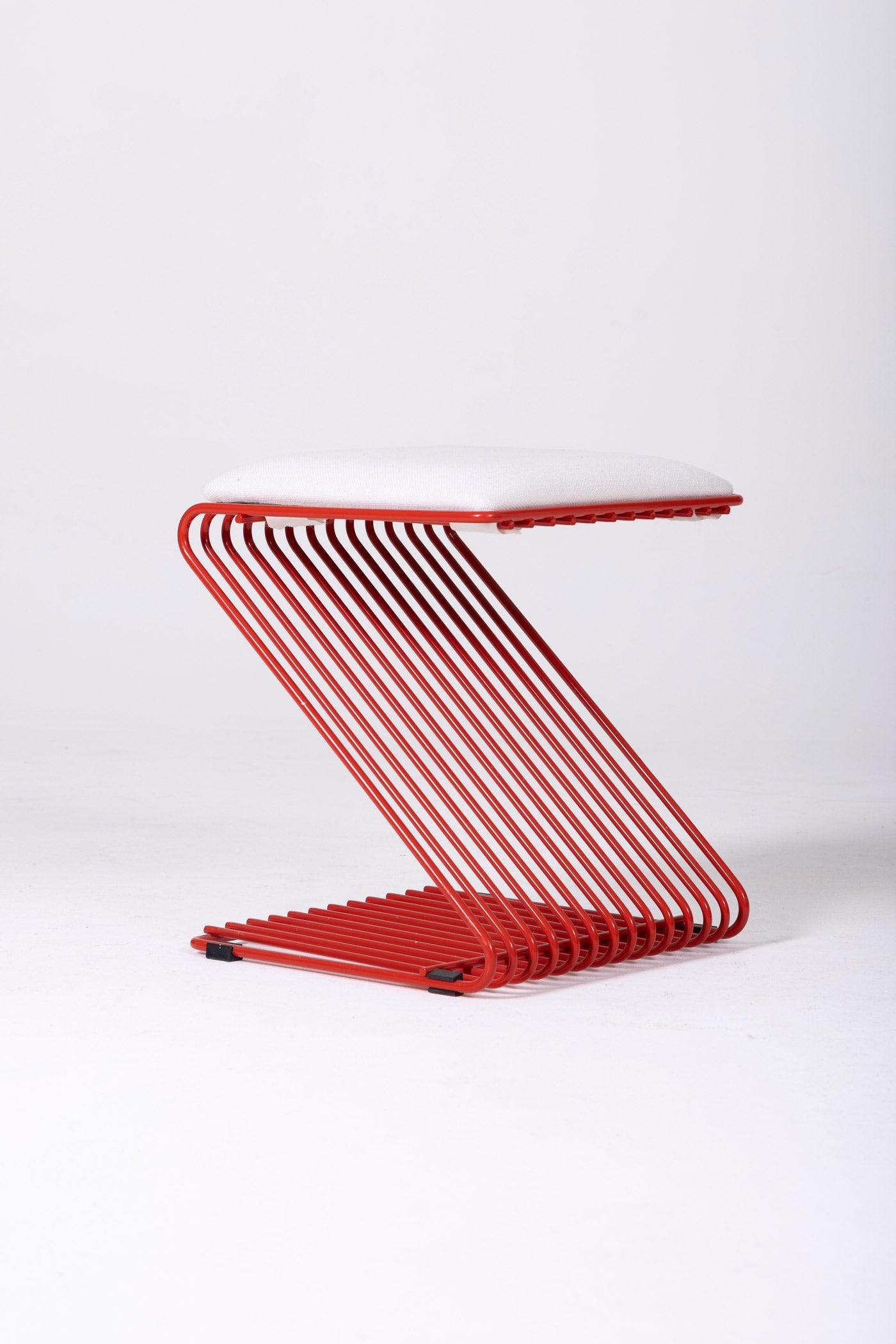 Tabouret Z du designer François Arnal pour l'Atelier A. Le coussin est en textile blanc et la structure tubulaire en métal laqué rouge. Parfait état.