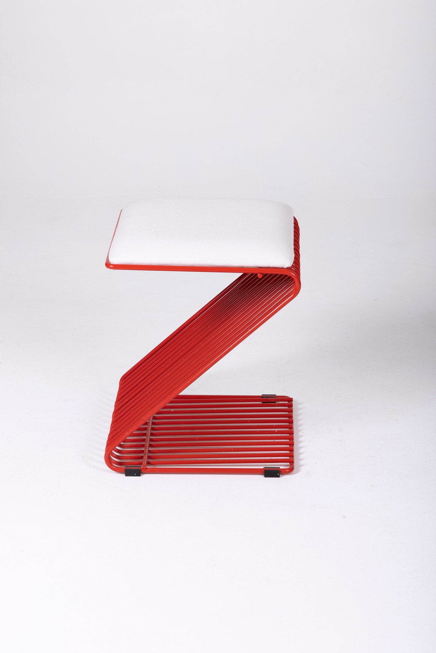 Tabouret Z du designer François Arnal pour l'Atelier A. Le coussin est en textile blanc et la structure tubulaire en métal laqué rouge. Parfait état.
