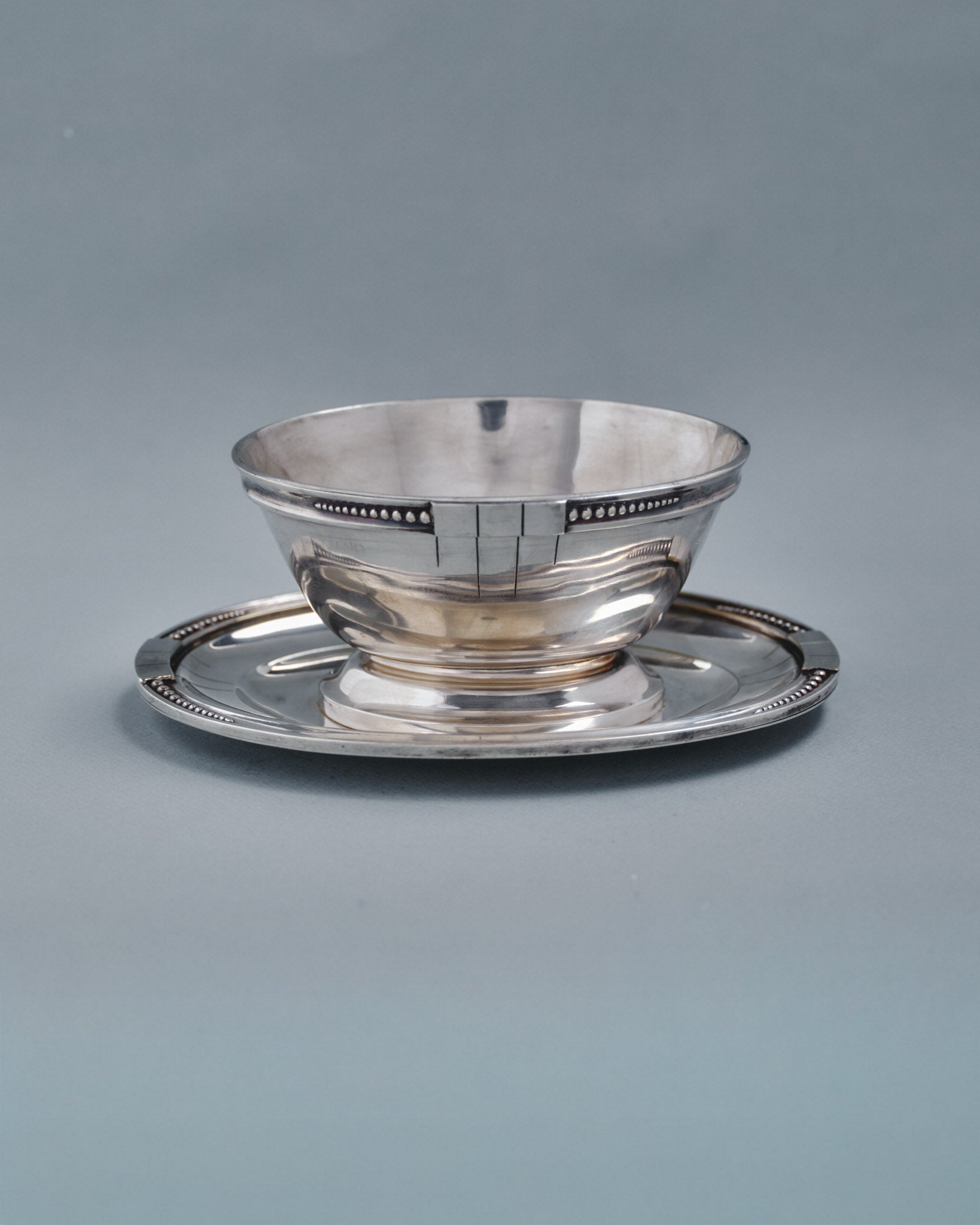 Saucière en métal argenté de l'orfèvre Samuel ASKENFELD. Décor de perle et de forme géométrique dans le style Art Déco. Très bel état, présente une patine conforme à l'âge et à l'usage.&nbsp;