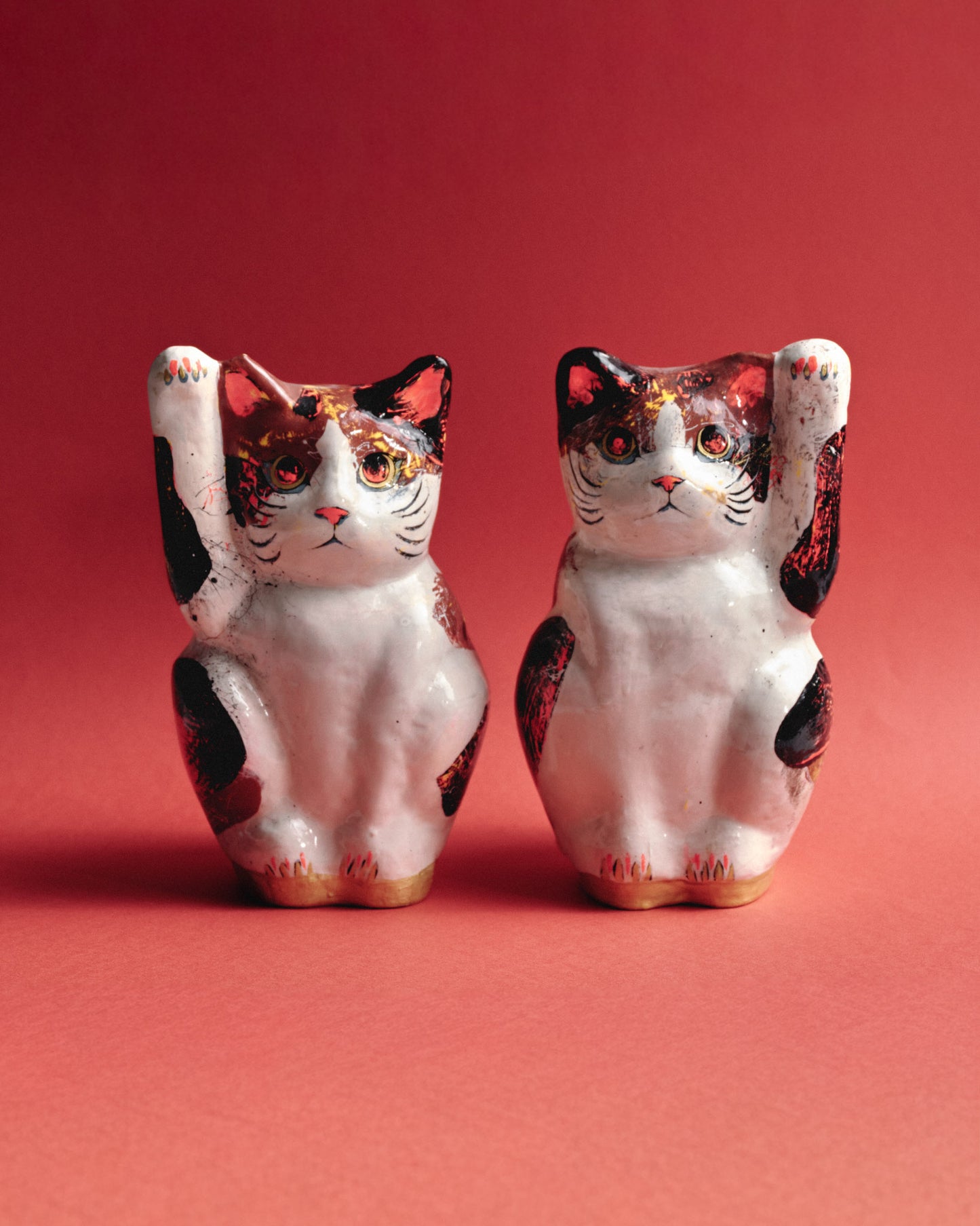 Paire de sculptures japonaises artisanales représentant deux chats Maneki-neko, symboles traditionnels de chance et de prospérité. Réalisées à la main en papier mâché peint. Les motifs peints à la main confèrent à chaque chat une personnalité unique. Parfait état.