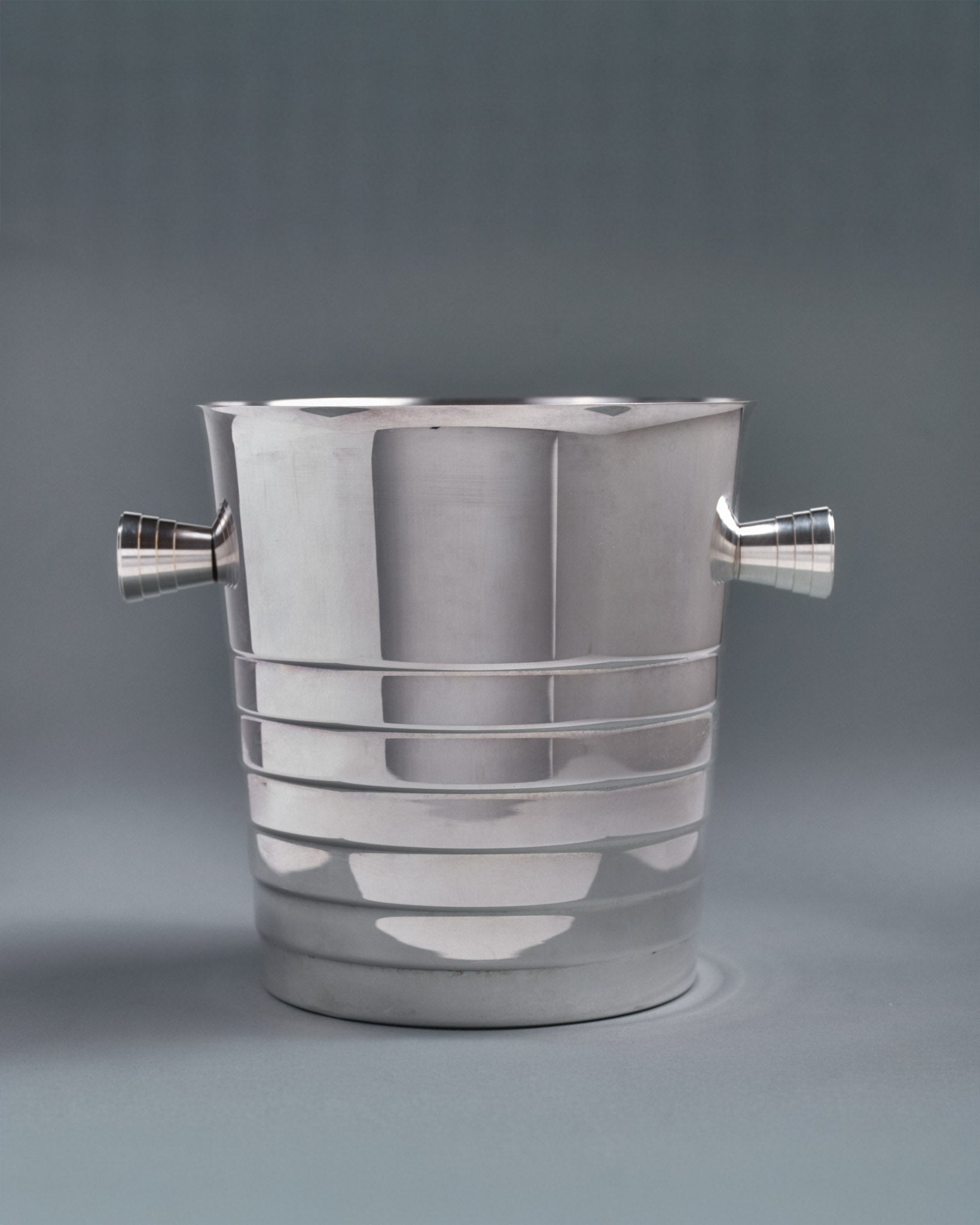 Seau à champagne en métal argenté, de la maison Christofle. Modèle Folio dans le style Art Déco. Poinçonné sous la base. Dans sa boîte d'origine, très bel état, présente une patine conforme à l'âge et à l'usage.