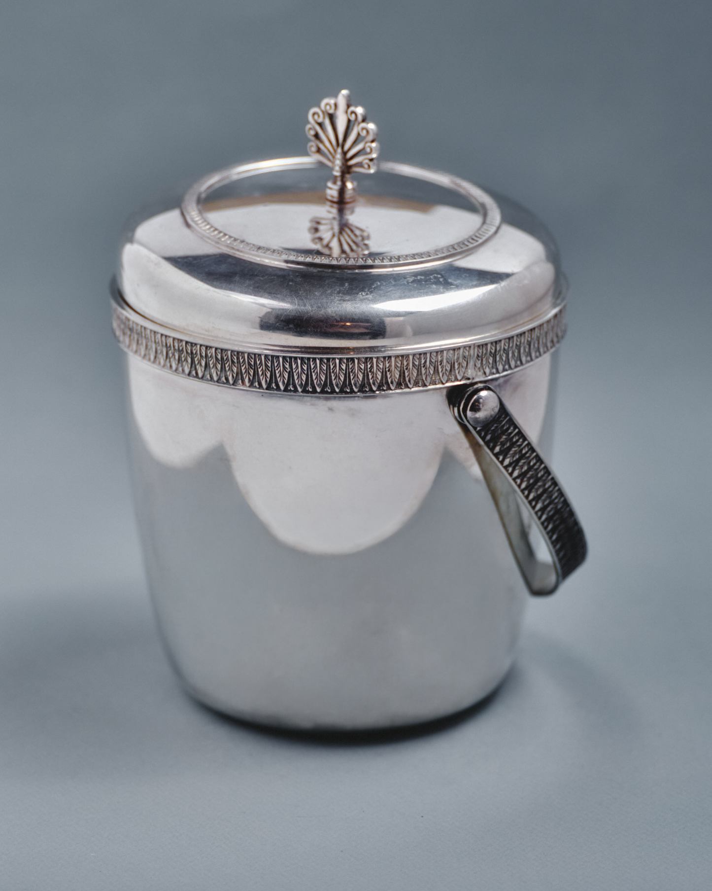 Seau à glaçons en métal argenté Thermid Paris, orné d'un décor ciselé à motif de frise géométrique et d'un bouton de couvercle en forme d'éventail stylisé. Typique du design français des années 1950-60. Bel état général, patine conforme à l'âge.