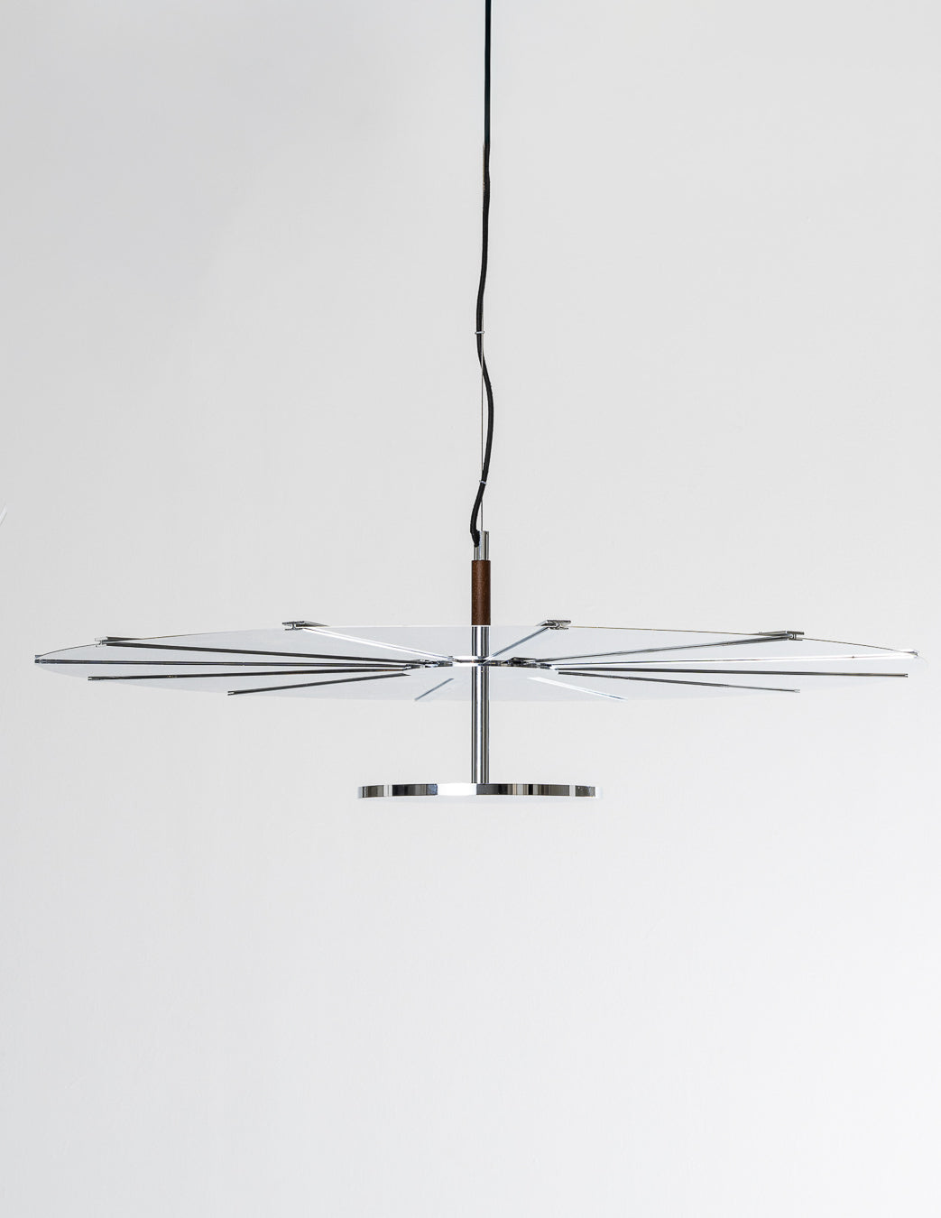 Suspension Madia par Baccaris, réalisée en chrome poli. Modèle édité exclusivement pour la Galerie Paradis dans cette finition. Composée de deux disques reliés par une structure centrale et des tiges métalliques fines, la suspension présente une forme graphique et équilibrée.