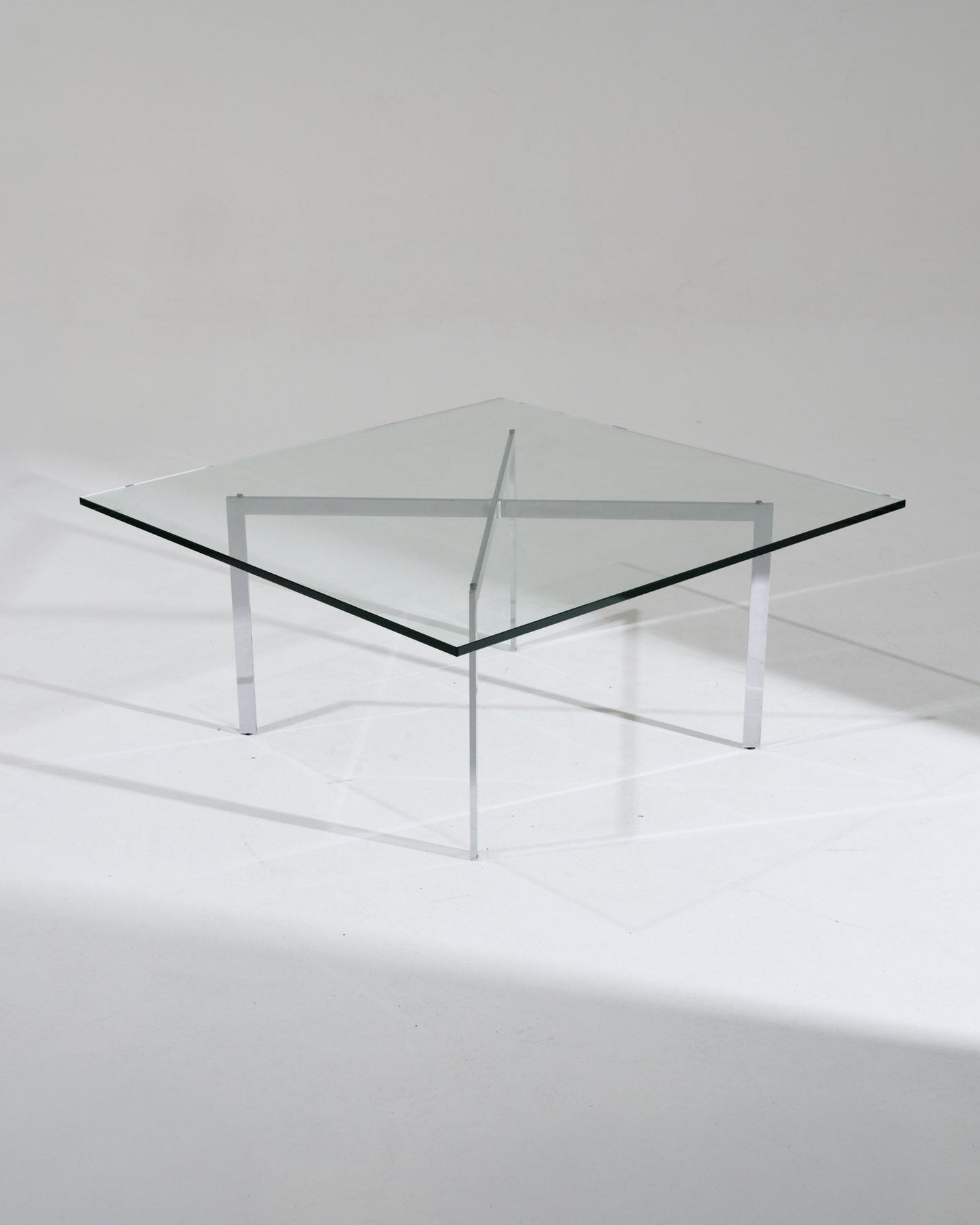 Table Barcelona par Ludwig Mies van der Rohe pour Knoll pour le pavillon allemand de l'Exposition universelle de 1929 à Barcelone. Structure en acier chromé croisé, plateau en verre épais. Très bon état vintage, légère patine sur le piétement.