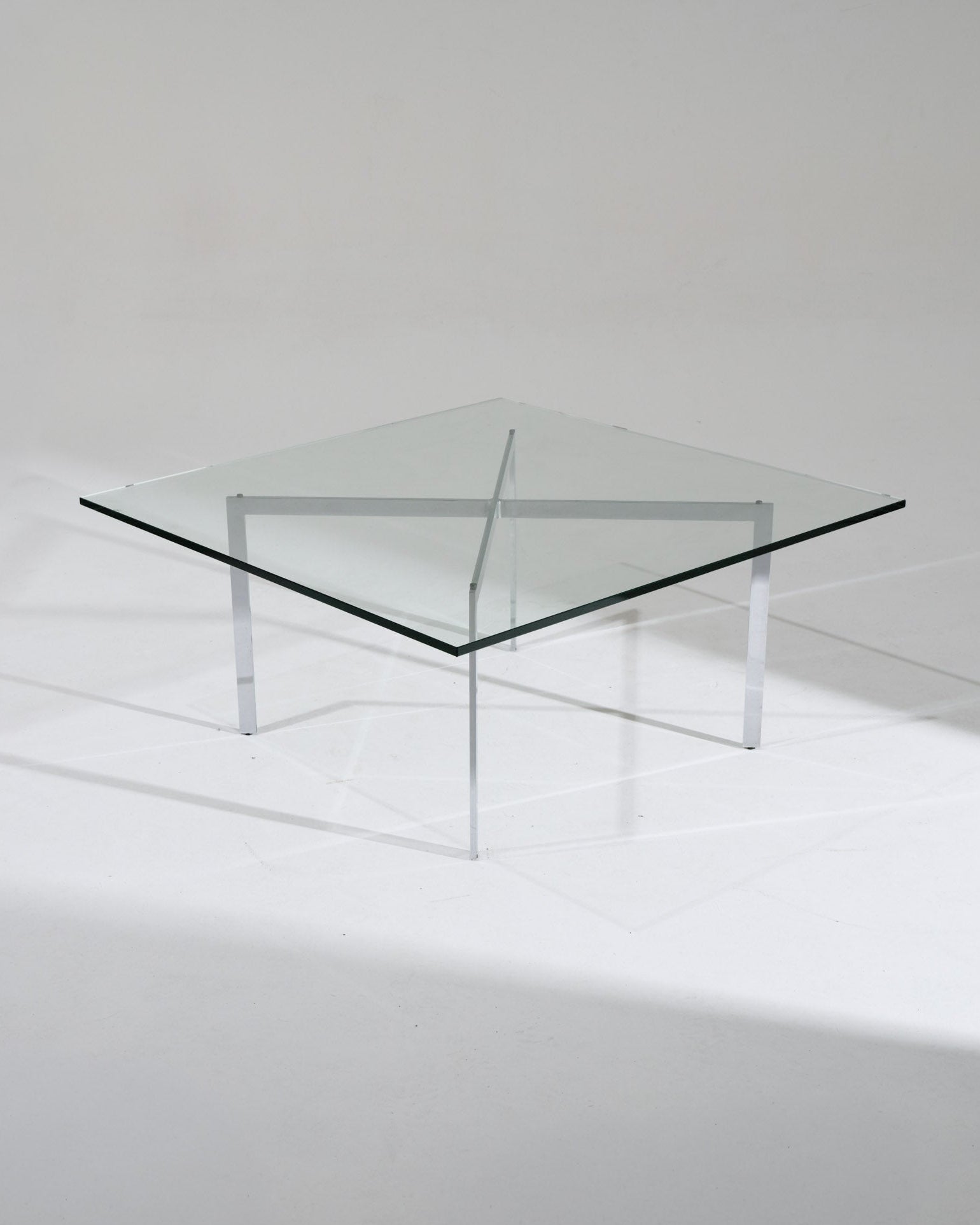 Table Barcelona par Ludwig Mies van der Rohe pour Knoll pour le pavillon allemand de l'Exposition universelle de 1929 à Barcelone. Structure en acier chromé croisé, plateau en verre épais. Très bon état vintage, légère patine sur le piétement.