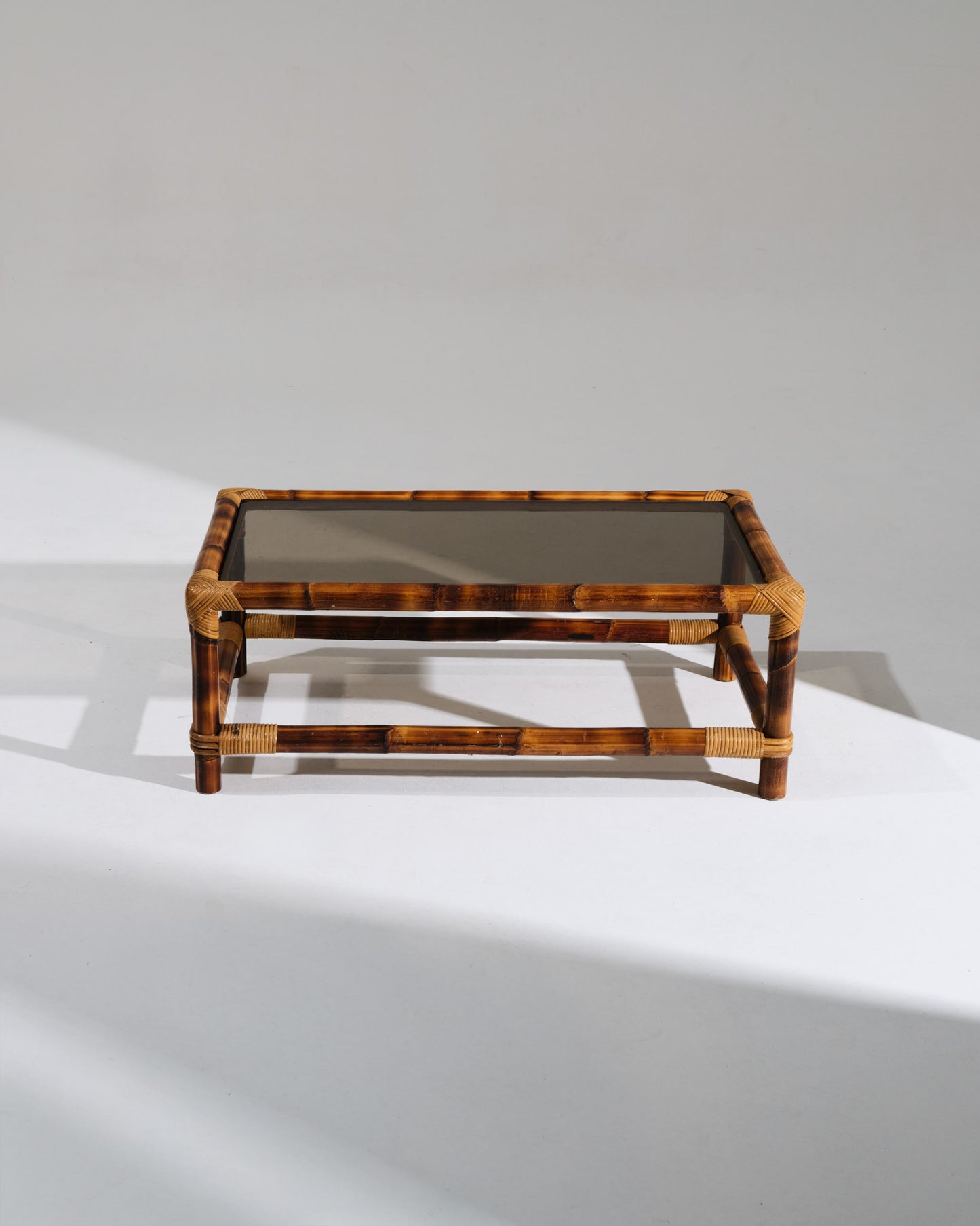 Table basse rectangulaire Audoux-Minet, emblématique du travail du couple de designers français. Structure en bambou naturel aux ligatures tressées, surmontée d'un plateau en verre transparent. Parfait état.&nbsp;