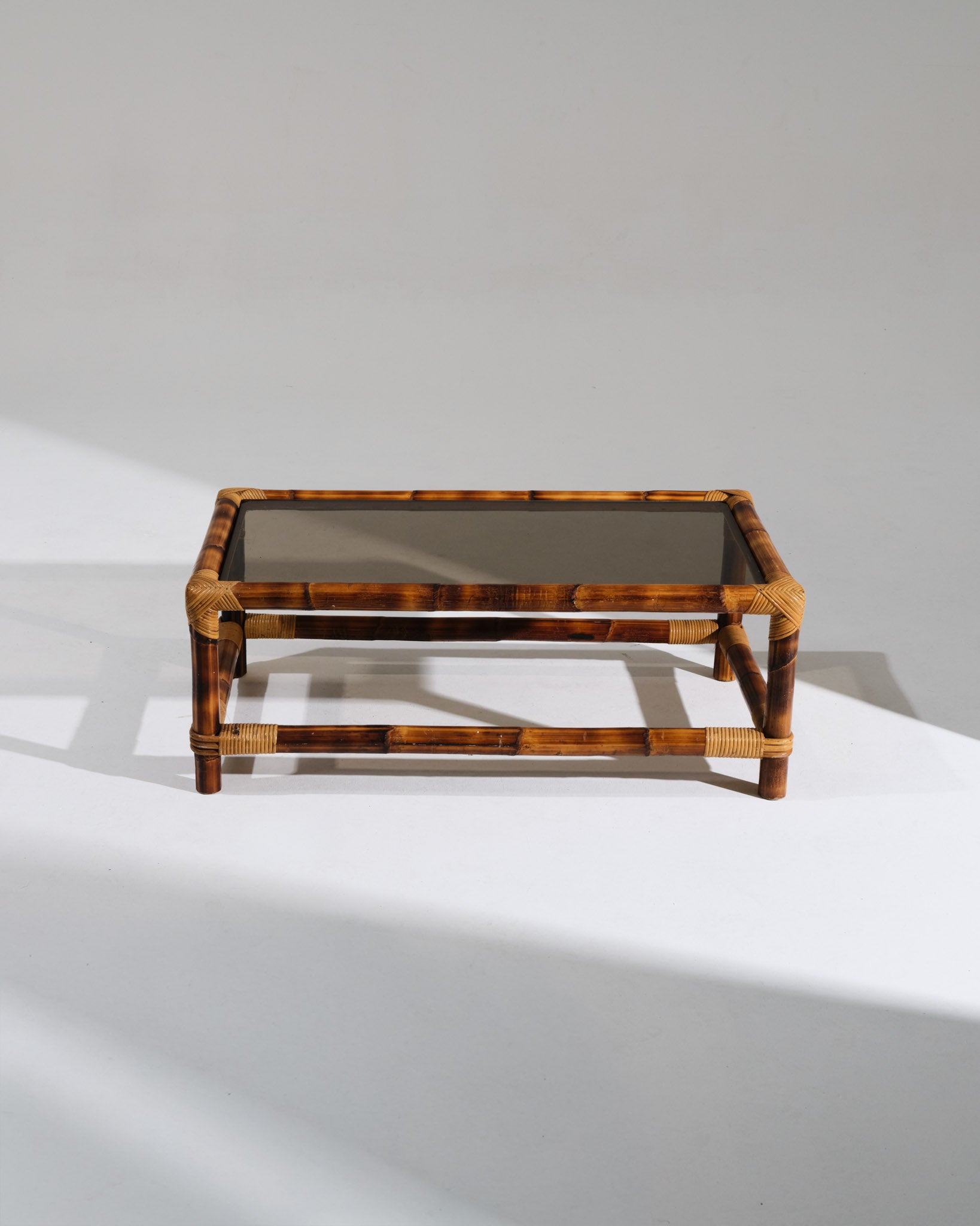 Table basse rectangulaire Audoux-Minet, emblématique du travail du couple de designers français. Structure en bambou naturel aux ligatures tressées, surmontée d'un plateau en verre transparent. Parfait état.&nbsp;