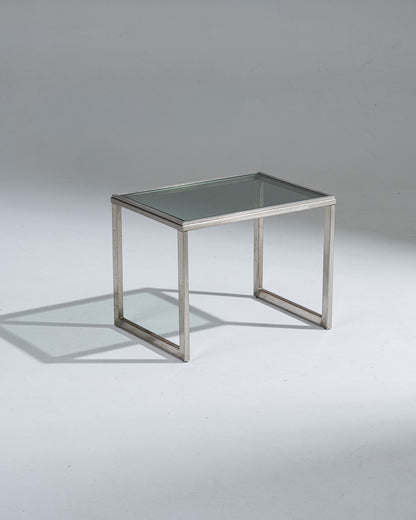 Petite table d'appoint rectangulaire en acier brossé et plateau en verre fumé. Patine sur l'acier et marque d'usure.