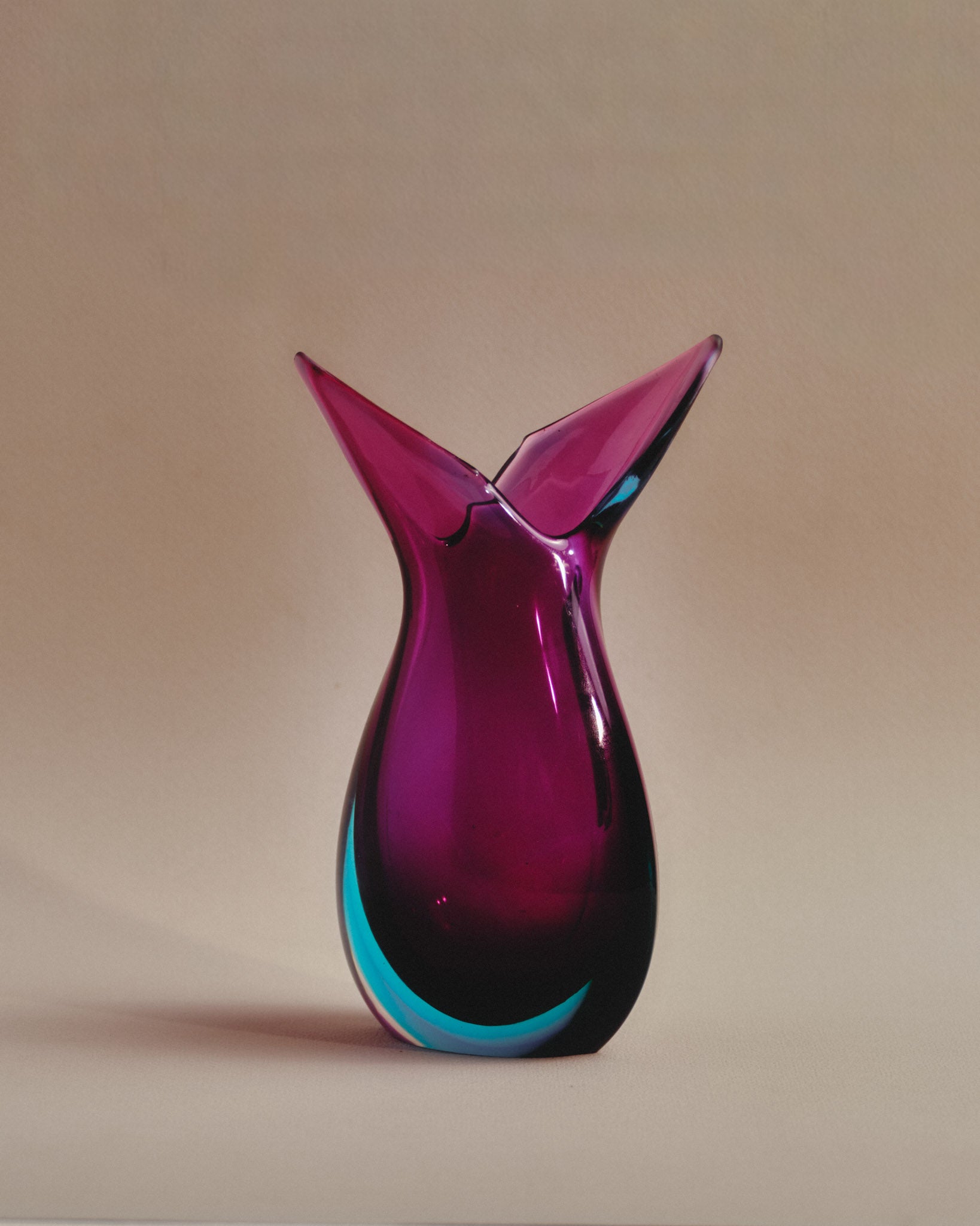 Vase en verre de Murano signé Archimede Seguso, datant des années 1950. Réalisé selon la technique du Sommerso (superposition de couches de verre coloré), il présente un dégradé de bleu lagon et violet améthyste, typique du savoir faire vénitien d'après-guerre.
Excellent état.