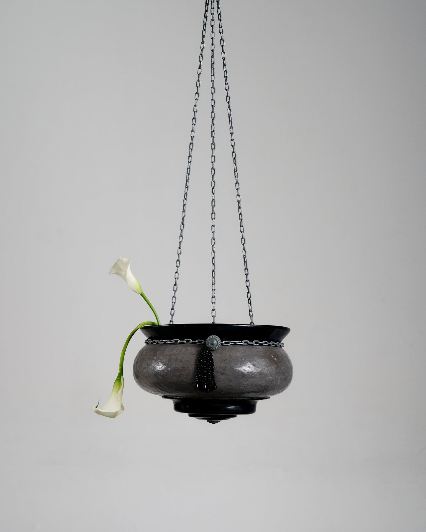 Suspension Le Brasero en forme de vasque réalisée par l'artiste Jordan Joevin. Structure en béton et bitume, suspendue par trois chaînes métalliques. Signature visible dans la vasque.