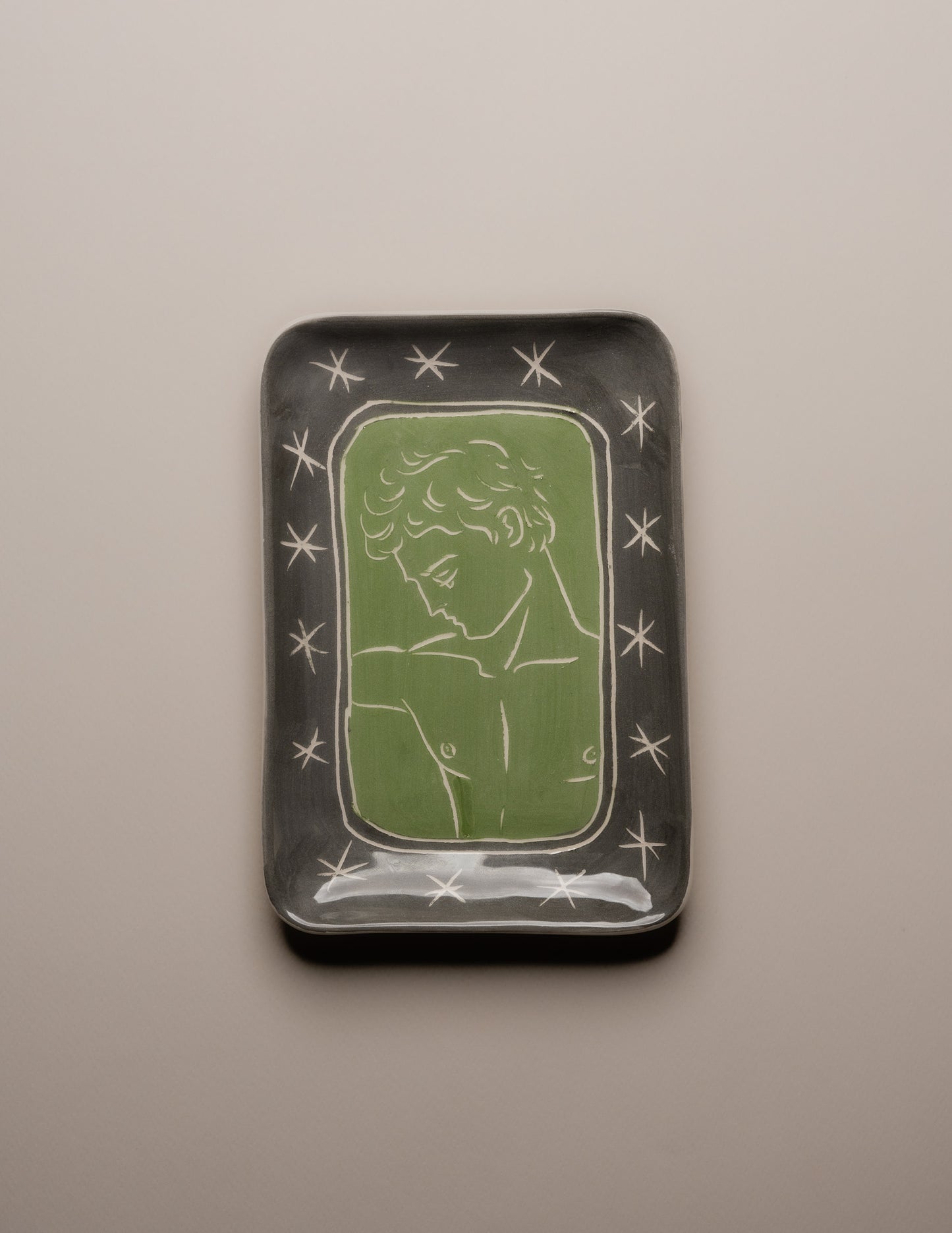 Vide-poche d’atelier en céramique émaillée verte, pièce unique signée « Eldarov. T 2024 » au revers. Sa forme rectangle à bords incurvés et la finesse de son émail témoignent d’une fabrication artisanale contemporaine.&nbsp; Pièce décorative à usage polyvalent, idéale pour accueillir des objets du quotidien ou comme élément sculptural sur un meuble d’appoint.